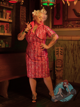 Pinup girl in tiki bar wearing 1950s style pencil dress in pink polynesian pattern with matching bolero
