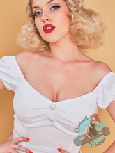 White ladies blouse in 1950s pinup style featuring gathered puff off the shoulder sleeves and decorative buttons. Perfect for a classic essential vintage style.
