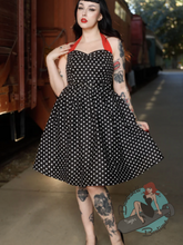 Pinup girl in black halter swing dress with white polka dots