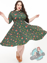 Plus size 1950s style pinup swing dress in green with foxes and leaves design.