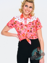 Pink Western pinup blouse featuring a kitschy 1950s cowboy print with hearts. Perfect for a pinup valentines look.