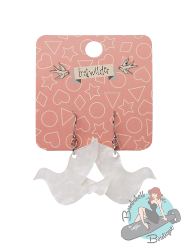 White dove-shaped earrings on a pink Erstwilder card 