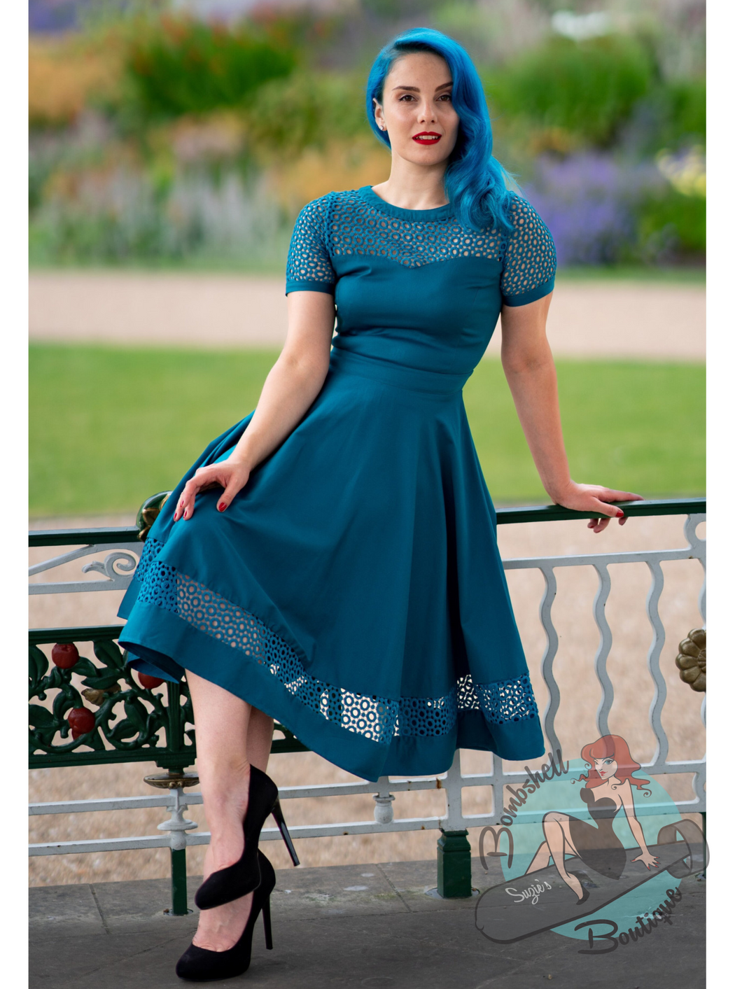 Turquoise swing dress with short sleeves and cut out lace detail on bodice and bottom of skirt. This is a classic 1950s style fit and flare dress. Perfect for bridesmaids or for a pin up holiday dress.