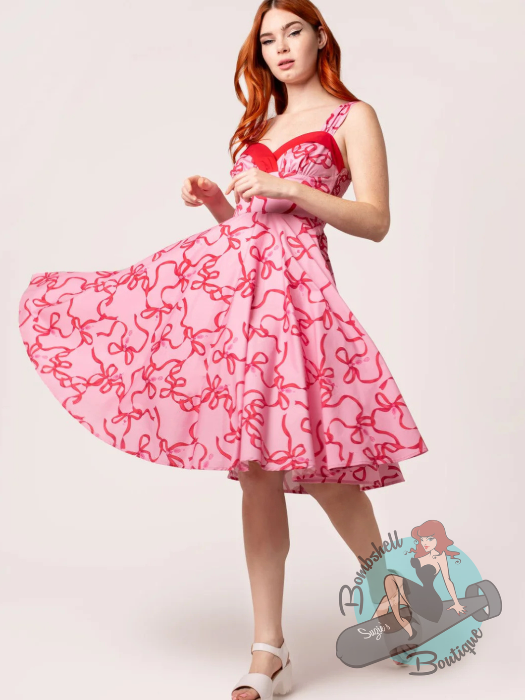 pinup girl in pink hell bunny canada swing dress with red bow print.