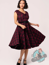 Pinup girl wearing black and burgundy tartan vintage style dress