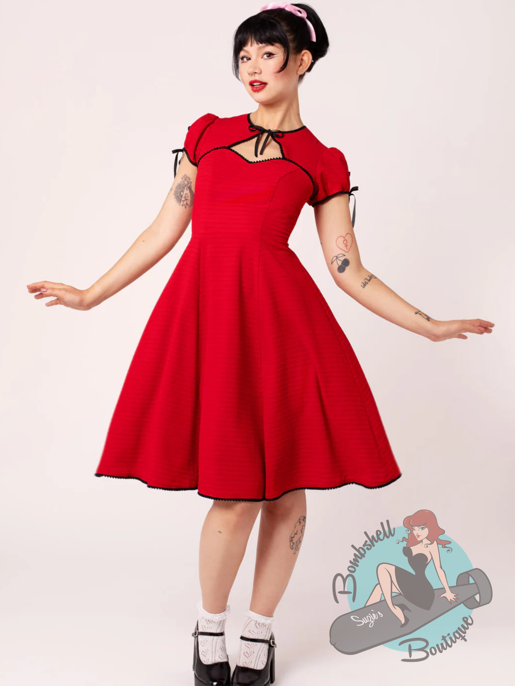 Pinup woman wearing hell bunny canada red swing dress with bolero style top