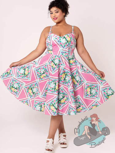 Plus sized woman in pinup swing dress with 1950s style full skirt and summer print