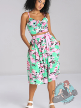 Pinup girl in pink and green hell bunny canada tiki skirt.