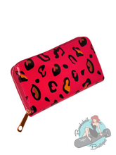 Red wallet with black and orange leopard print on a white background, featuring Bombshell Boutique logo.