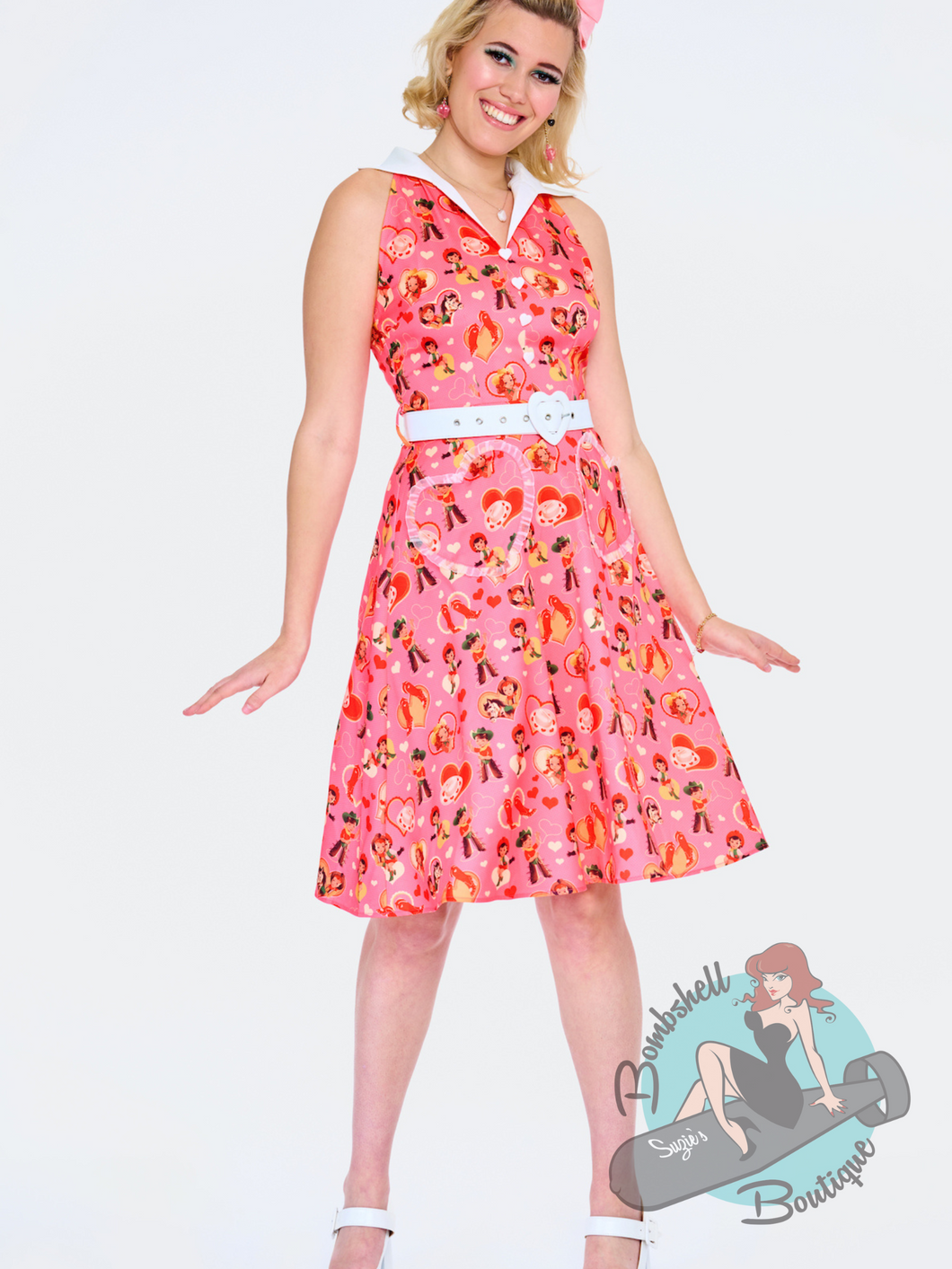 This cute fit and flare dress features a pink and red kitschy western valentine's print, ruffled heart pockets, and white accent collar. This is a pretty western pinup dress, perfect for a rockabilly show.
