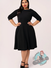 Plus size pinup girl wearing classic black Audrey Hepburn style vintage dress