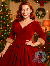 Pinup girl at vintage christmas party wearing red velvet 1950s swing dress