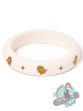 Medium width white bakelite look bangle with glittery gold bells and inlaid gold starburst gems. The perfect accessory for your pin up festive look.