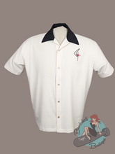 Cream button down bowling shirt with short sleeves, black collar, and atomic boomerang starburst embroidery on chest. This is a 1950s vintage inspired shirt for rockabilly guys.