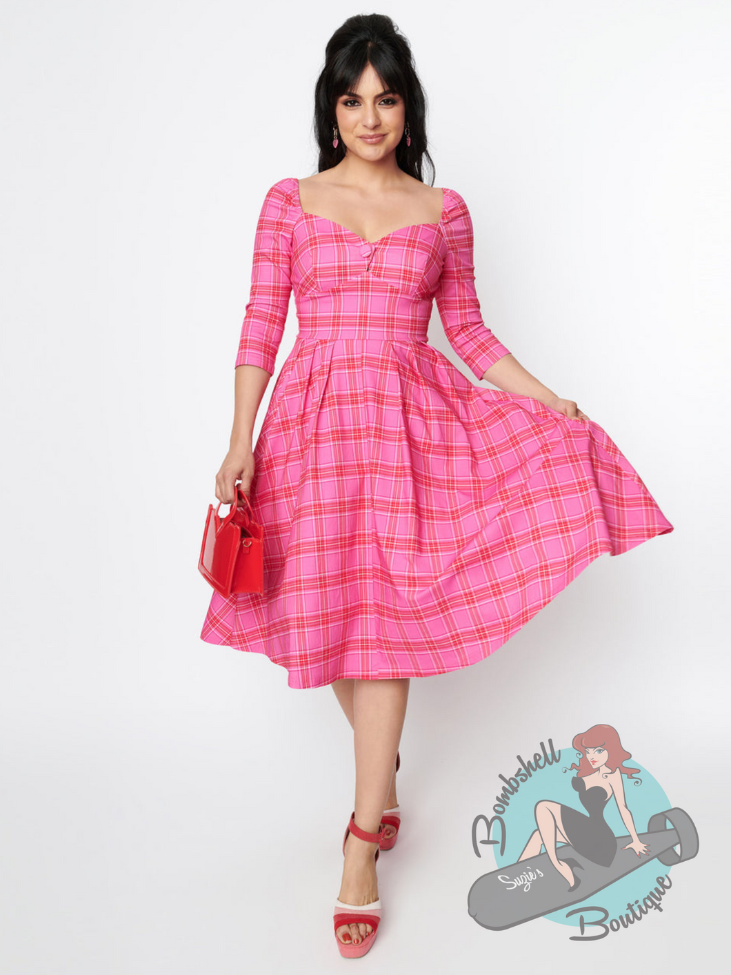 Pink tartan vintage inspired swing dress in 1950s pinup style featuring a pink and red tartan, sweetheart neckline, and pockets.