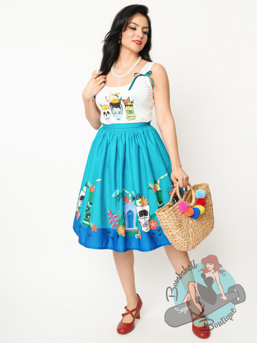 High waisted gathered 1950s swing skirt in blue and teal with print of tiki drinks and skulls and tiki monsters. This skirt combines tiki, spooky, and pinup style.