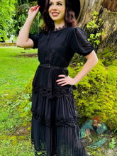 woman wearing gothic style goth black dress with lace trim 